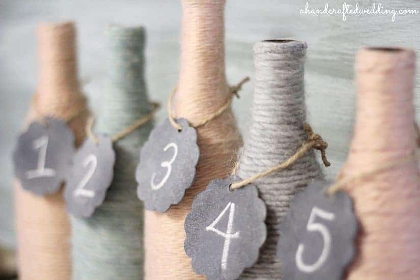 Check out how to upcycle bottles into Yarn Wrapped Bottle Vases or Table Numbers for your Wedding Reception Decor | MountainModernLife.com