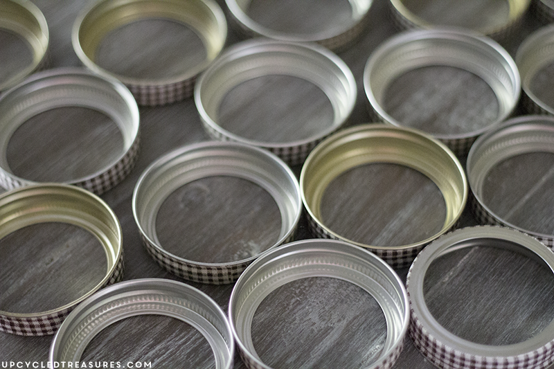 See how easy it is to create this rustic fall mason Jar lid pumpkin using canning lids, fabric tape, fishing line and a stick!