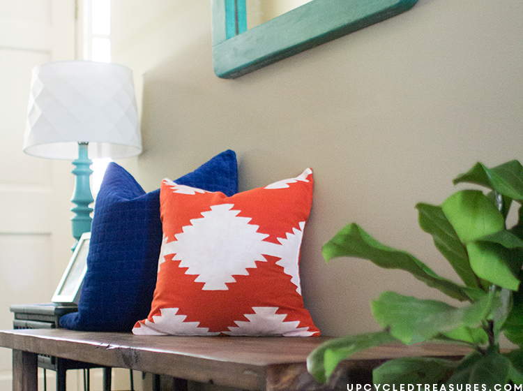Kilim inspired painted pillow resting on bench in foyer. MountainModernLife.com