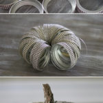 See how easy it is to create this rustic fall Mason Jar lid pumpkin using canning lids, fabric tape, fishing line and a stick!
