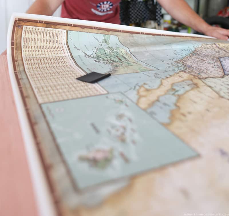 adding peel and stick map to piece of plywood