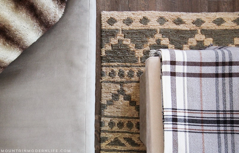 RV interior with a plaid blanket on top of folding ottoman