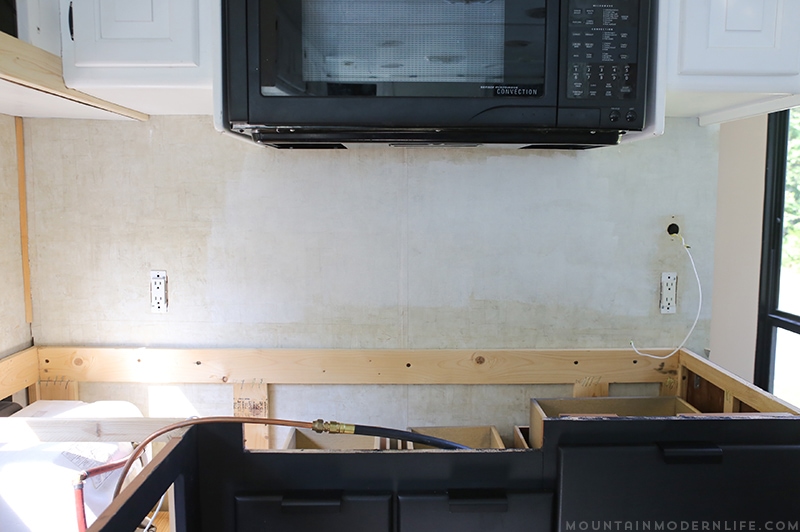 Easily install a wood planked kitchen backsplash in a RV! This is the perfect way to add rustic modern or farmhouse style to your tiny home on wheels!