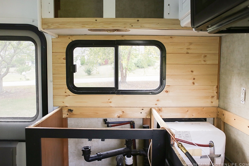 Easily install a wood planked kitchen backsplash in a RV! This is the perfect way to add rustic modern or farmhouse style to your tiny home on wheels!
