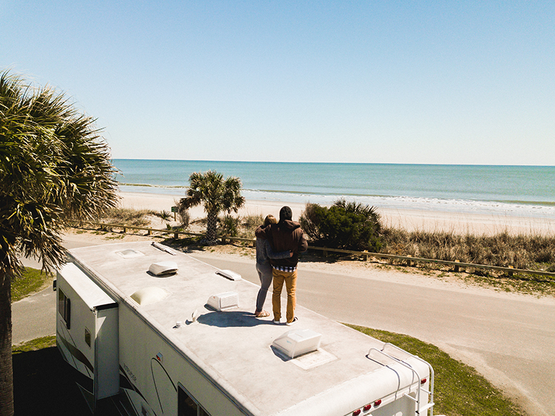 couple standing on roof of RV