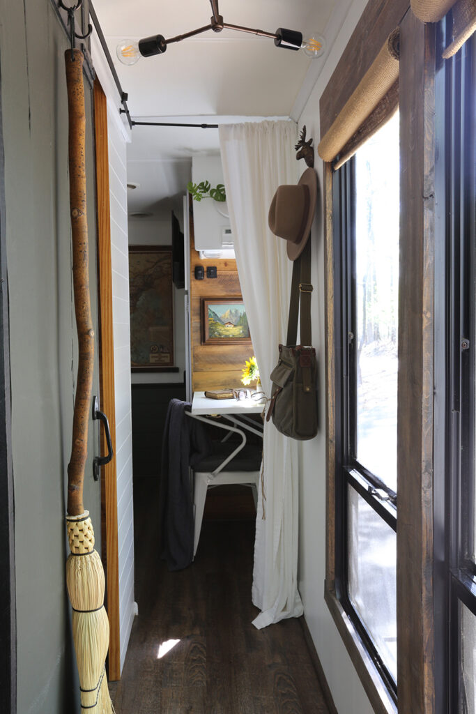 green sliding barn door in RV with handmade broom